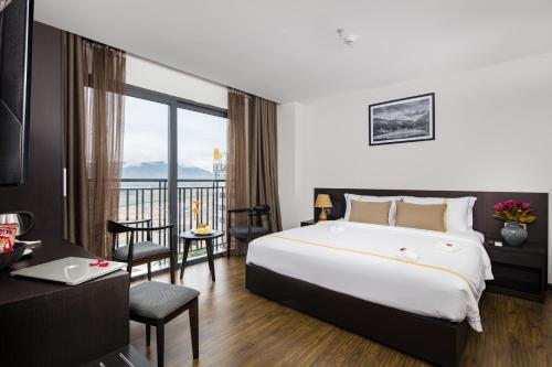 a hotel room with a large bed and a balcony at La Sera Hotel in Nha Trang
