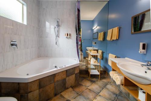 a bathroom with a tub and a sink at Tuscany On Thames in Thames