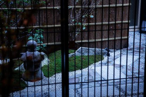 a gate with a bird sitting on the grass at Hotel Kanazawa Zoushi in Kanazawa