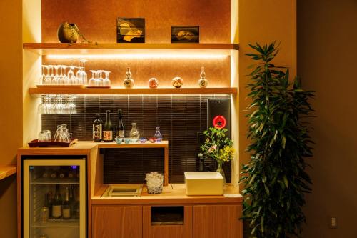 a bar with a shelf with bottles and glasses at Hotel Kanazawa Zoushi in Kanazawa