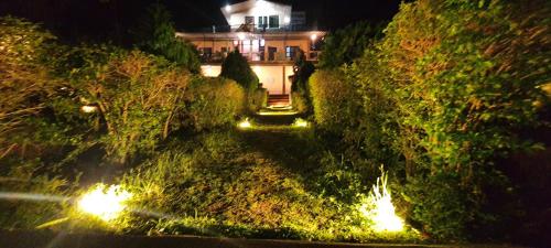 a house on a hill at night with lights at Karthik Resorts, Jeolikote Nainital in Nainital
