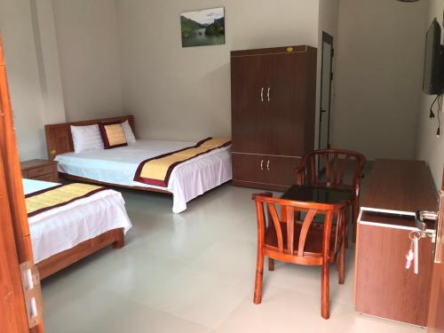 a room with two beds and a desk and a chair at Nha nghi PAC NGOI in Bak Kan