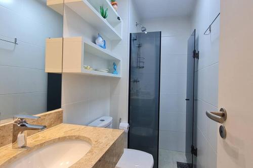 Un baño con inodoro, lavabo y ducha. en Apê dos Anjos, en Arraial do Cabo