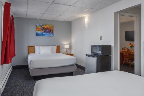 a hotel room with two beds and a television at Golden North Inn in Fairbanks