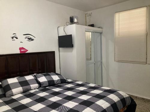 a bedroom with a black and white checkered bed at The Little Blue House in Guayama