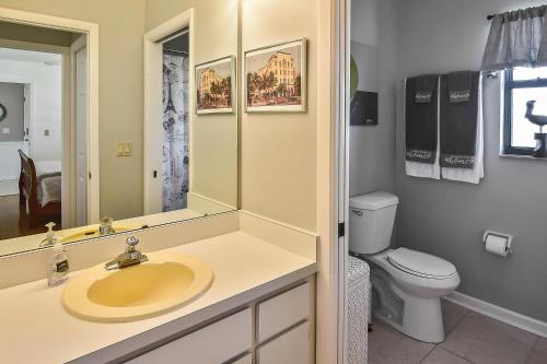 a bathroom with a sink and a toilet and a mirror at Isles Golf Home in Punta Gorda
