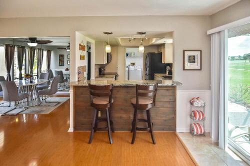 a kitchen and living room with a bar with stools at Isles Golf Home in Punta Gorda