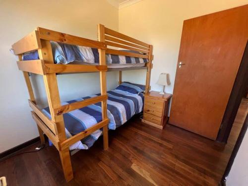 a bedroom with two bunk beds and a wooden floor at River Panorama Beach House in Guilderton