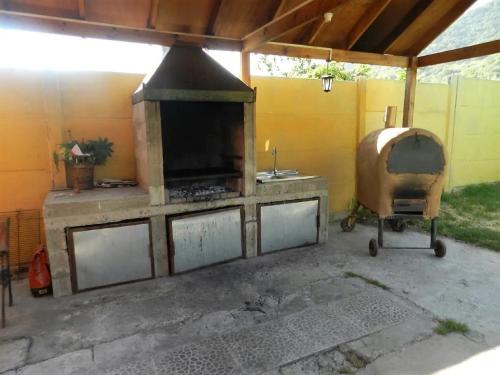 an outdoor kitchen with an outdoor oven in a patio at Casona Campestre Santa Filomena in Granizo