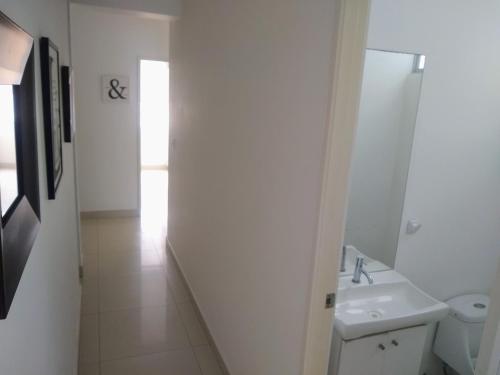 La salle de bains blanche est pourvue d'un lavabo et de toilettes. dans l'établissement Departamento en Punta Hermosa con Vista al Mar, à Punta Hermosa