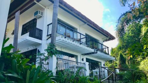 - un bâtiment blanc avec des balcons et des escaliers dans l'établissement Villas by Eco Hotels Batangas, à Mataasnakahoy