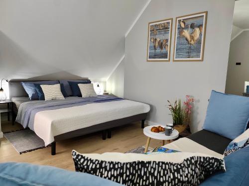 - une chambre avec un lit et un canapé dans l'établissement Apartament GRAY CRANE, à Giżycko