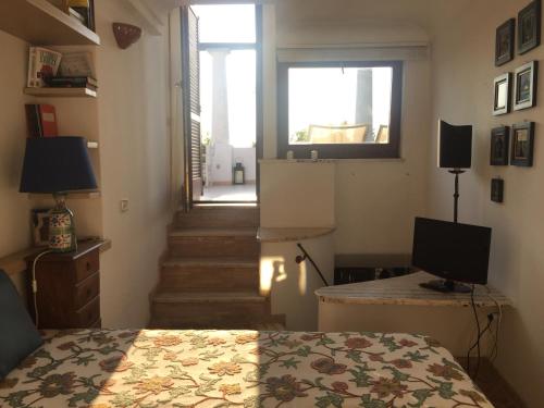 ein Schlafzimmer mit einem Bett, einem Fenster und einer Treppe in der Unterkunft Casa Capri Sunset in Anacapri