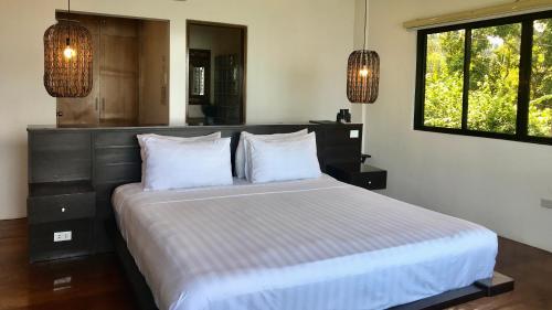 a bedroom with a large bed with two pillows at Villas by Eco Hotels Batangas in Mataasnakahoy