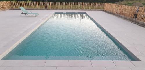- une piscine avec une chaise à côté dans l'établissement La clef des champs 3, à Meillac