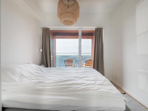a bedroom with a large white bed and a window at New Danish Design flat - 10 minutes to city centre in Copenhagen