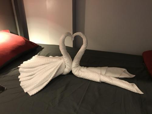 two swans made out of towels on a bed at WELKOM INN in Can Tho