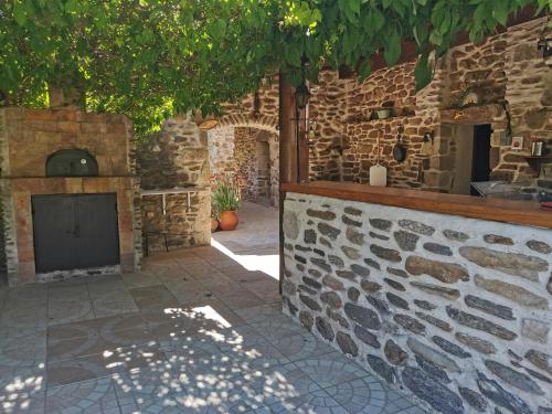 a stone building with a fireplace in a courtyard at Mes Maisons Gardoises, Two Gites sleeping 13 with Two Private pools, Kids Room, Laundry, Disco, free WiFi, Linen and Dog's are Welcome in Gagnières