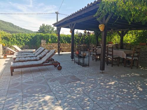 a patio with chairs and tables and a blue canopy at Mes Maisons Gardoises, Two Gites sleeping 13 with Two Private pools, Kids Room, Laundry, Disco, free WiFi, Linen and Dog's are Welcome in Gagnières