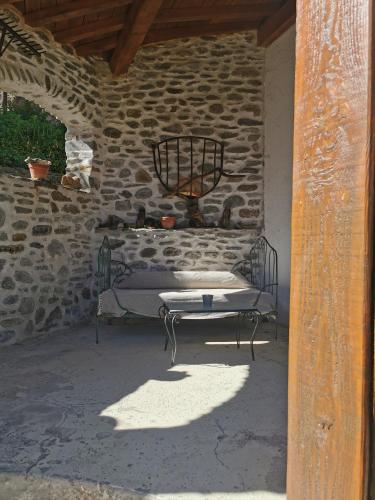 a bed in a stone building with a table at Mes Maisons Gardoises, Two Gites sleeping 13 with Two Private pools, Kids Room, Laundry, Disco, free WiFi, Linen and Dog's are Welcome in Gagnières