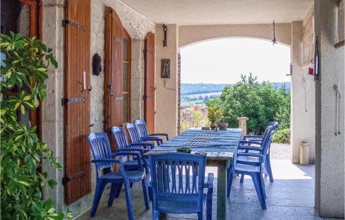 une longue table bleue et des chaises sur une terrasse dans l'établissement Lovely Home In Cauzac With Kitchen, à Cauzac