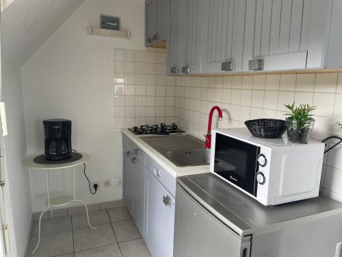 a kitchen with a microwave on top of a counter at Lebraz 3 Appartement in Saint-Lunaire