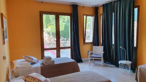 Una habitación con dos camas y una gran ventana. en Villa Dammusello, en Marsala