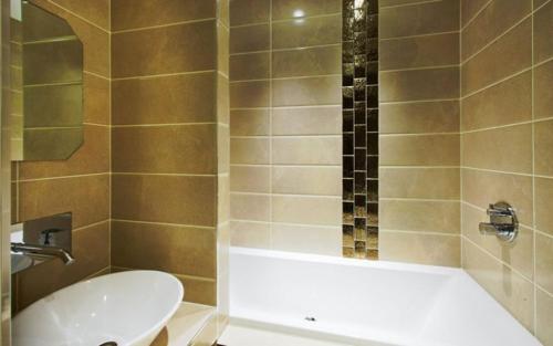 a bathroom with a tub and a toilet and a sink at Applegarth Villa Hotel & Restaurant (Adult Only) in Windermere