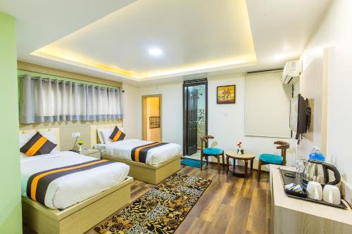 a hotel room with two beds and a tv at Hotel Travel INN in Kathmandu
