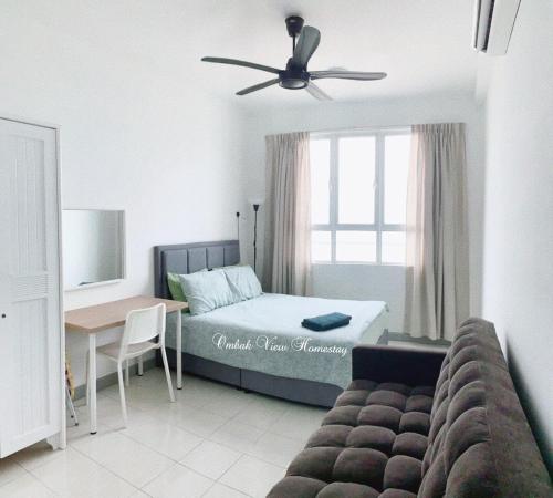 a bedroom with a bed and a table and a window at New Seaview Families Suite - Breezy Blue in Kuala Terengganu