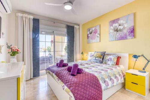 sypialnia z łóżkiem z fioletowymi poduszkami w obiekcie Hanami Puerto Alto PA 7-7 w mieście Estepona