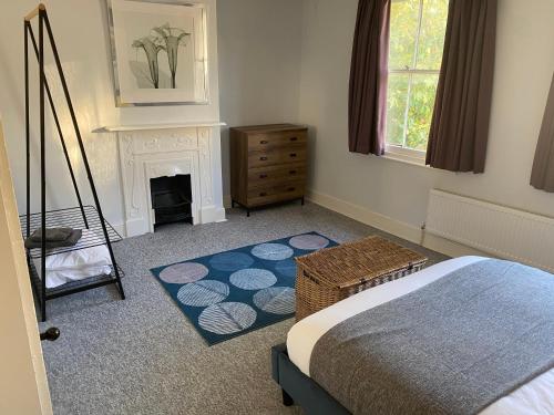 a bedroom with a bed and a fireplace and a room with a bed sqor at Invicta Apartment in Ashford