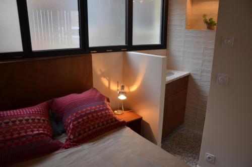una camera con letto, 2 cuscini e una lampada di Super studio a Saint-Denis