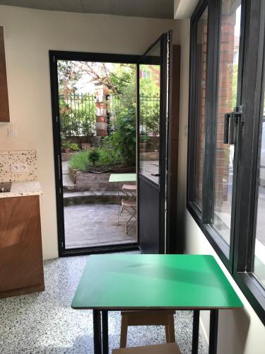 a green table in a room with a window at Super studio in Saint-Denis