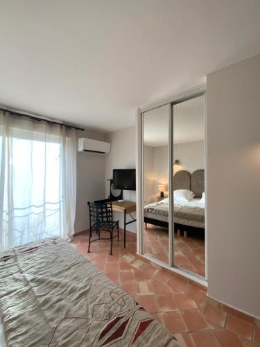 a bedroom with a bed and a mirror at Hôtel l'Arena in Fréjus