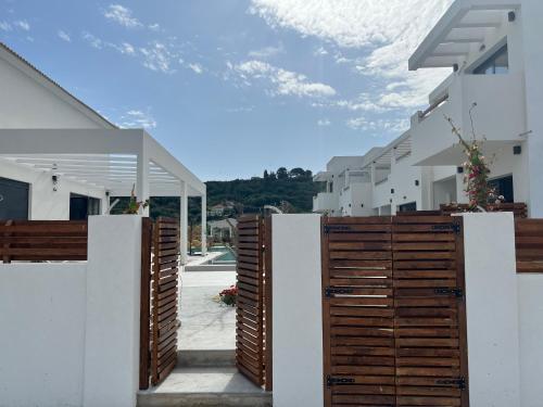 a row of white buildings with wooden doors at Κimiro Hotel Tsilivi in Planos