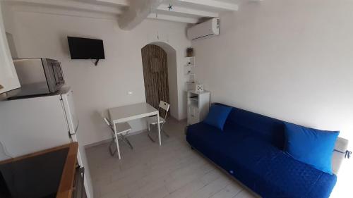 - un salon avec un canapé bleu et un bureau dans l'établissement MaRosa, à Montignoso