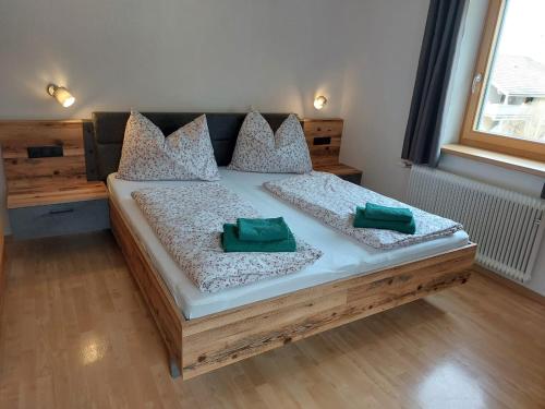 ein Schlafzimmer mit einem Bett mit zwei grünen Kissen darauf in der Unterkunft Schmiederlerhof in Neustift im Stubaital