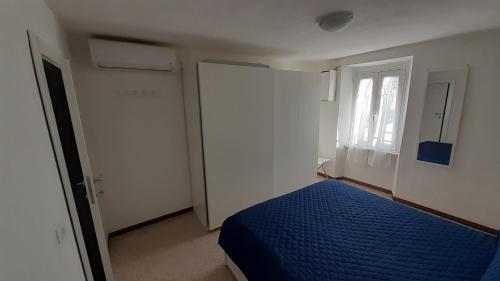 - une chambre avec un lit bleu et une fenêtre dans l'établissement MaRosa, à Montignoso