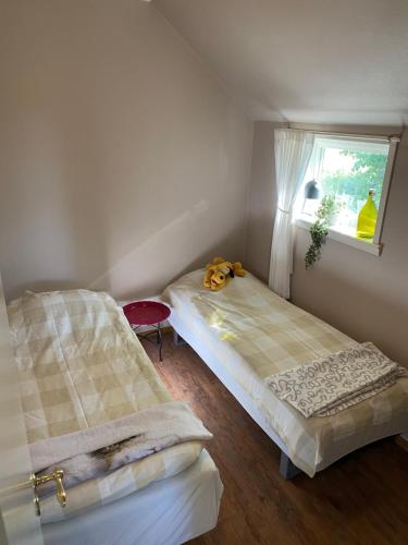 two beds in a small room with a window at Lilla Sandslätt in Åhus