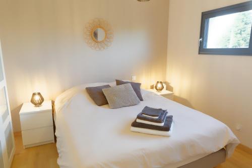 une chambre avec un lit blanc avec des serviettes dessus dans l'établissement La Venise Normande, à Pont-Audemer