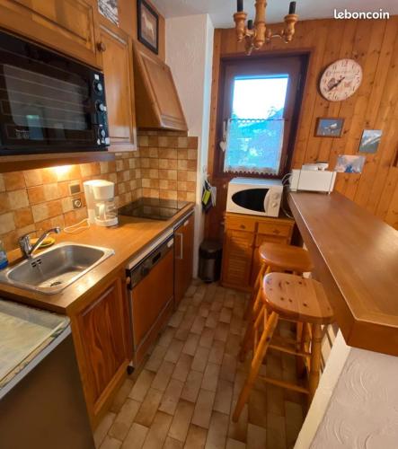 une petite cuisine avec un évier et un comptoir dans l'établissement Le Clos d'Arly, à Praz-sur-Arly