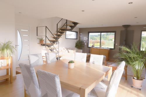 une salle à manger avec une table en bois et des chaises blanches dans l'établissement La Venise Normande, à Pont-Audemer