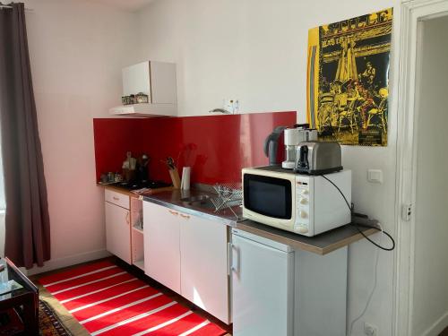 une cuisine avec un four micro-ondes au-dessus d'un comptoir dans l'établissement T2 Quartier du Rosmeur, à Douarnenez