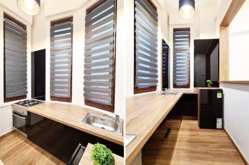 two views of a kitchen with blinds on the windows at Picky Apartment in Arad