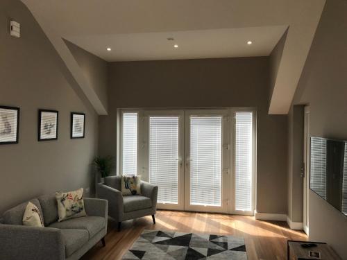 a living room with a couch and a chair at Stable Court Apartments in Antrim