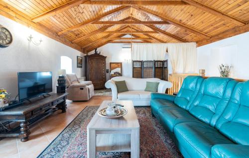 a living room with a blue couch and a tv at Villa Lenoir in Vrsar