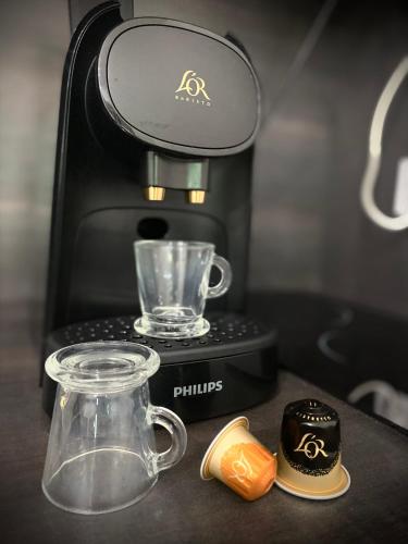 une cafetière assise sur un comptoir avec un récipient en verre dans l'établissement Love Room avec jacuzzi & lit King Size, à Saint Etienne