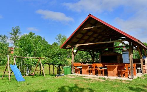 a pavilion with a picnic table and a playground at Apartments Laura in Rakovica