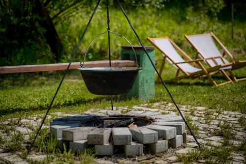a fire pit with a bucket and two chairs at Parkside Vila in Odorheiu Secuiesc